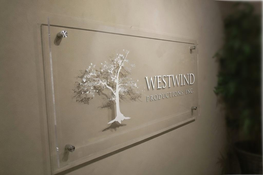 Clear acrylic Westwind office lobby sign with laser-engraved tree and stainless-steel spacers in Toronto
